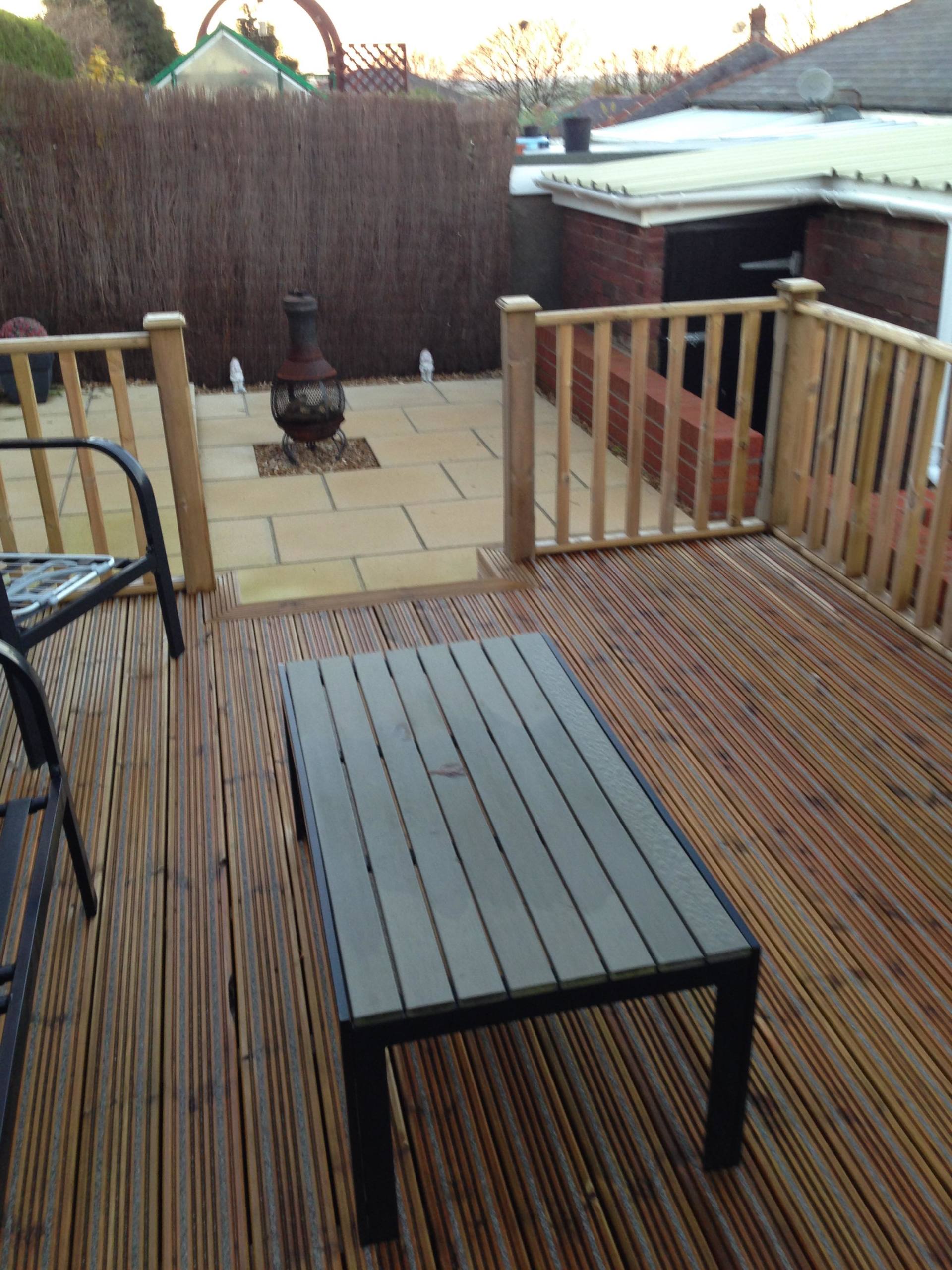 new deck installation in the garden area with wooden bench