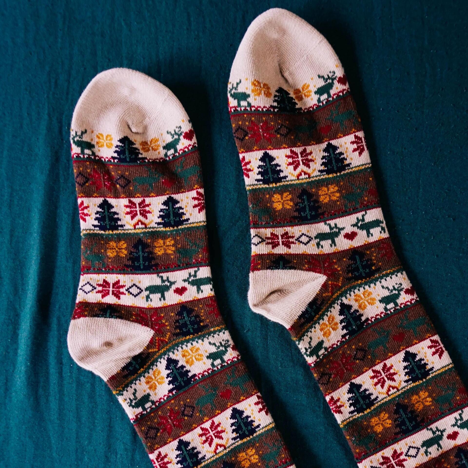 A pair of socks with a pattern on them are sitting on a blue surface.