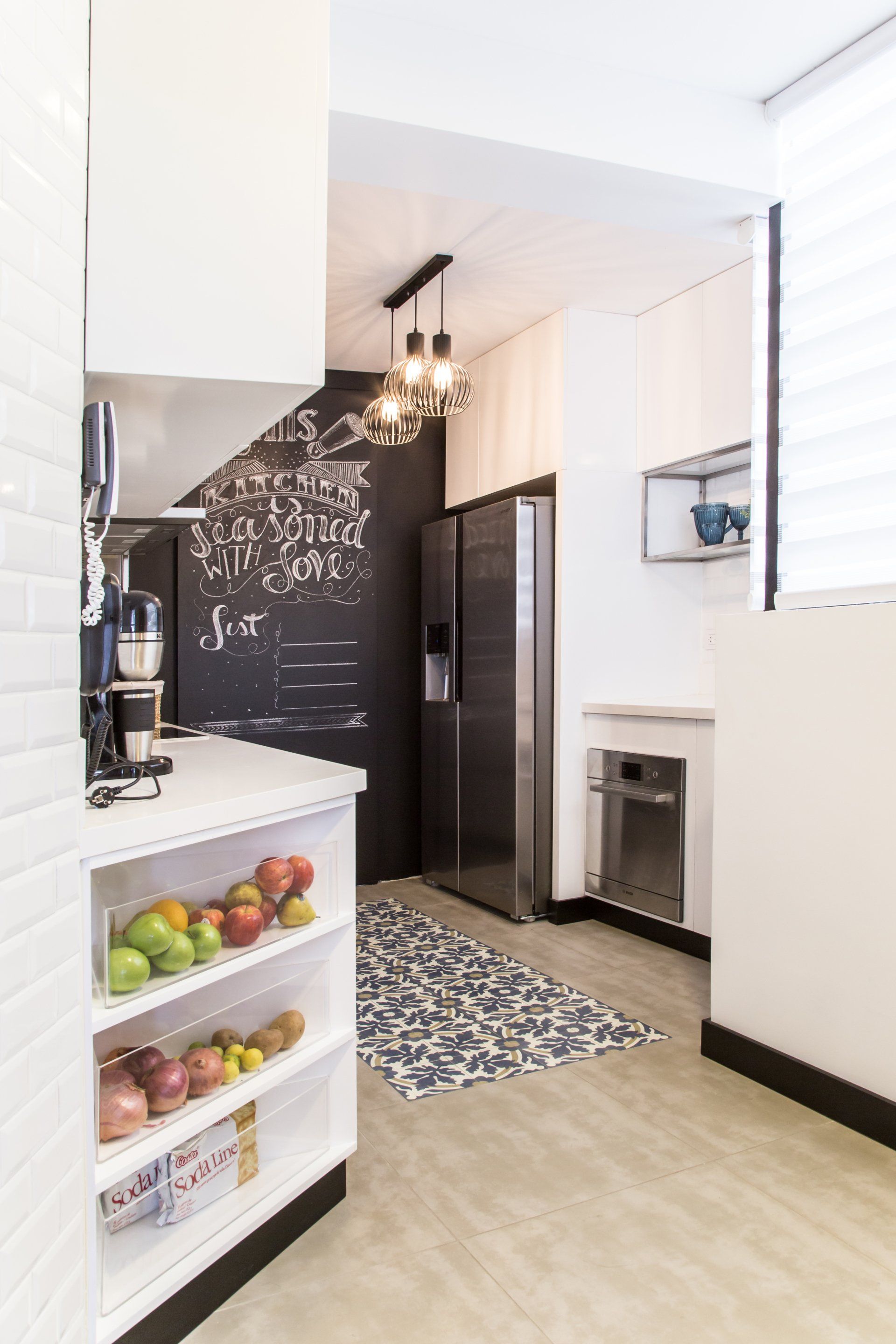 Una cocina con refrigerador y una pizarra en la pared.