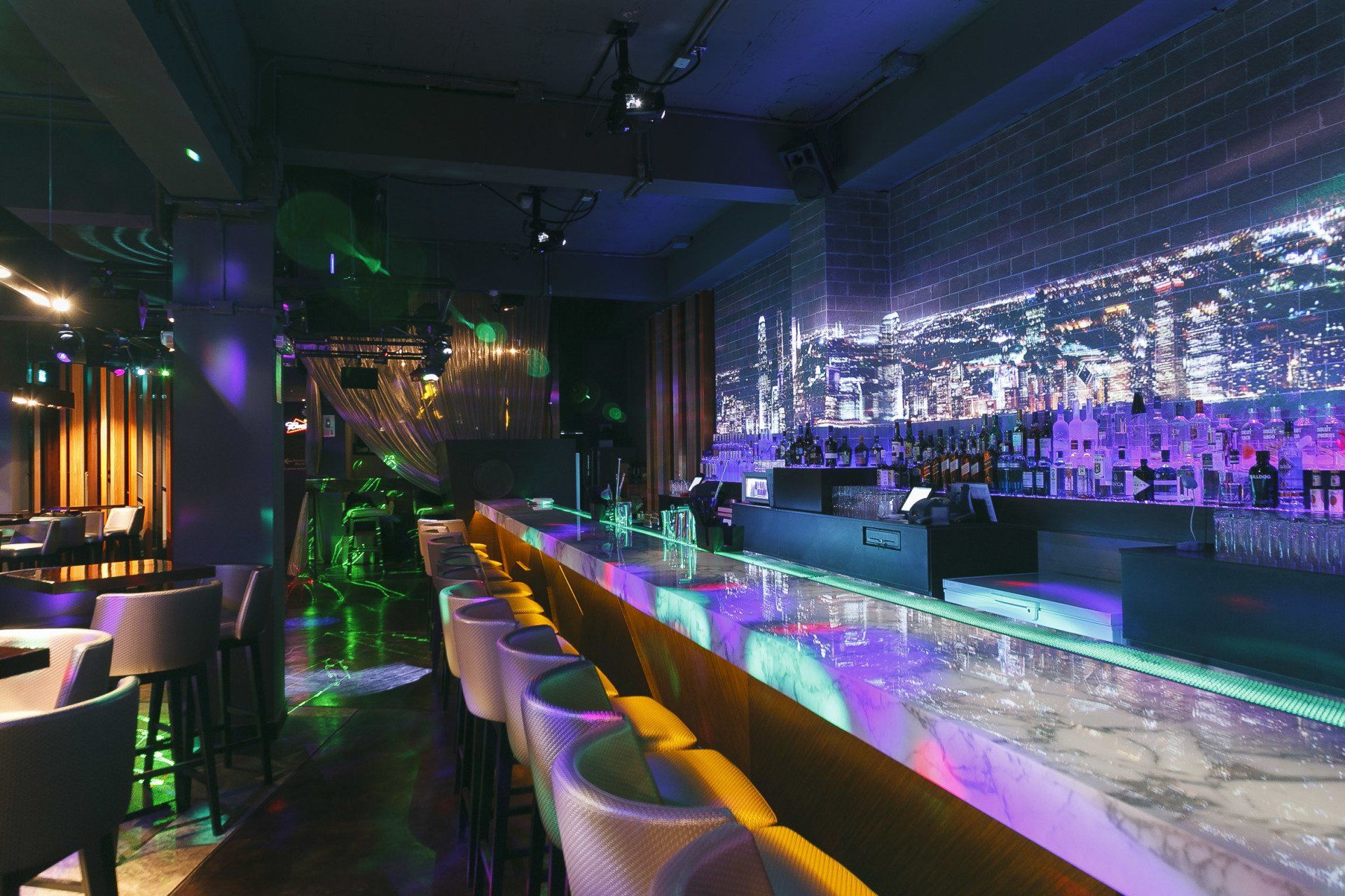 Una barra larga en una discoteca con muchas luces.