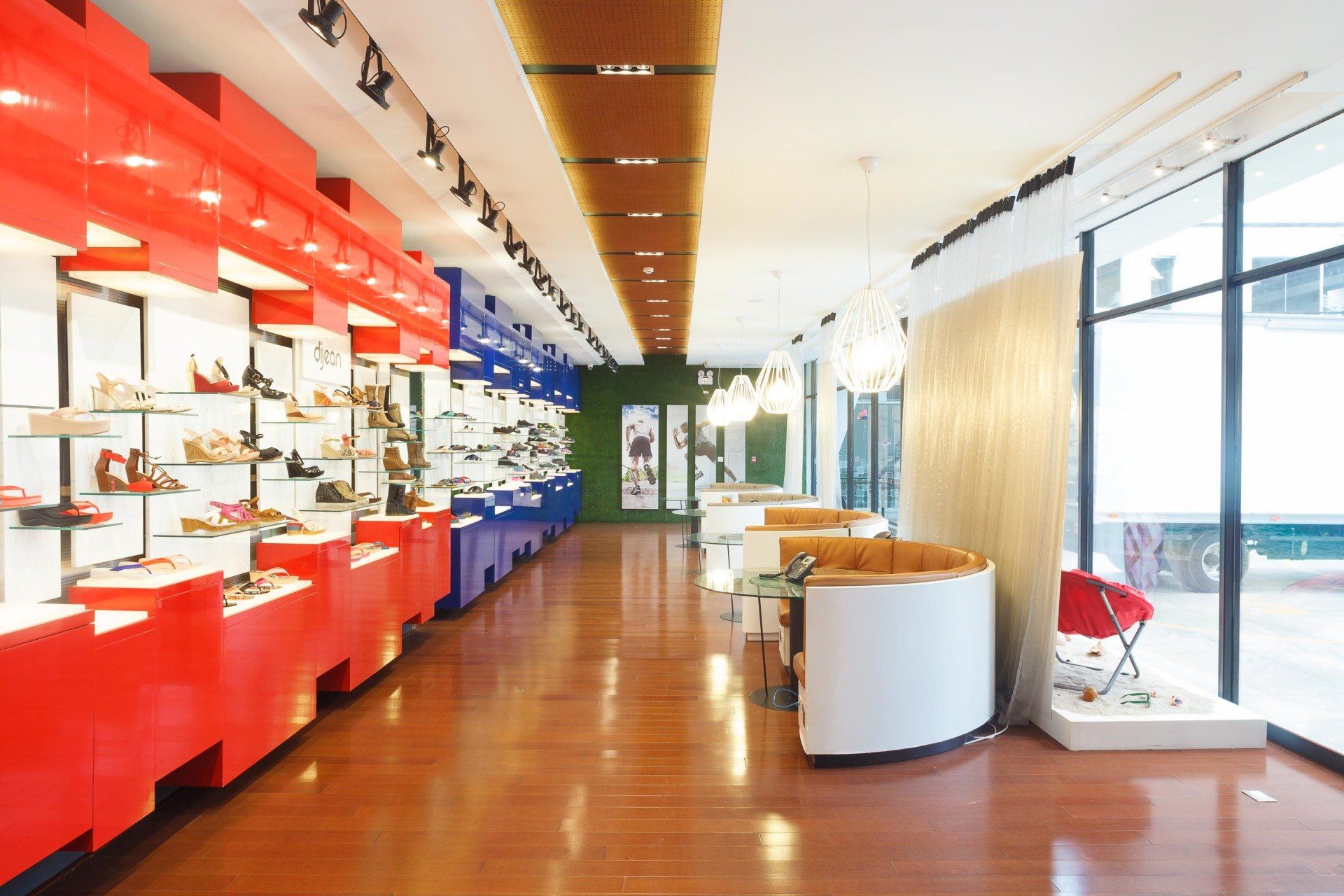 Un largo pasillo en una zapatería con muchos zapatos en exhibición.