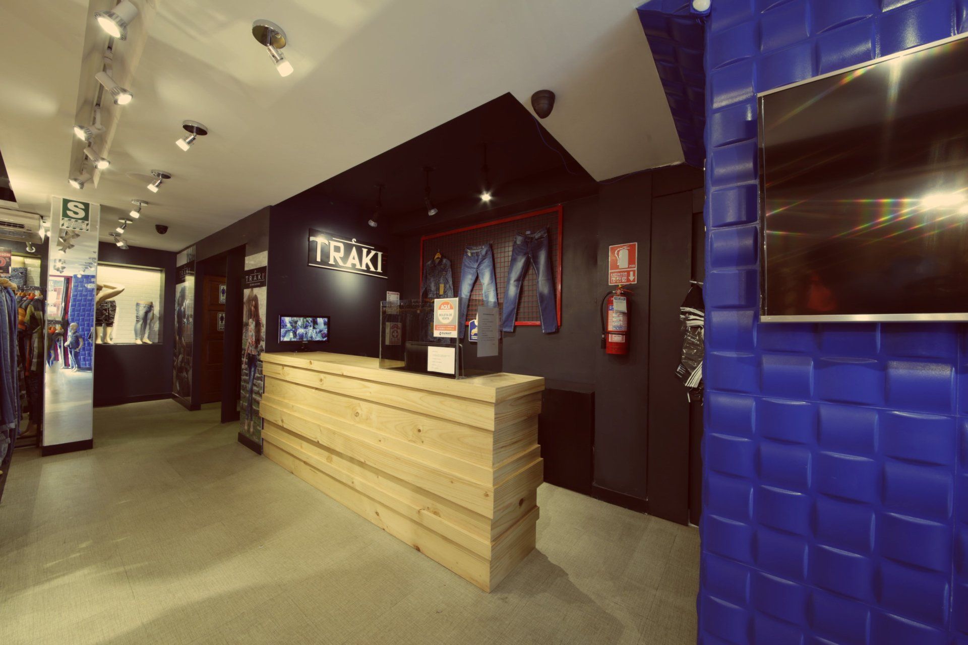 Una tienda con un mostrador de madera y un televisor en la pared.
