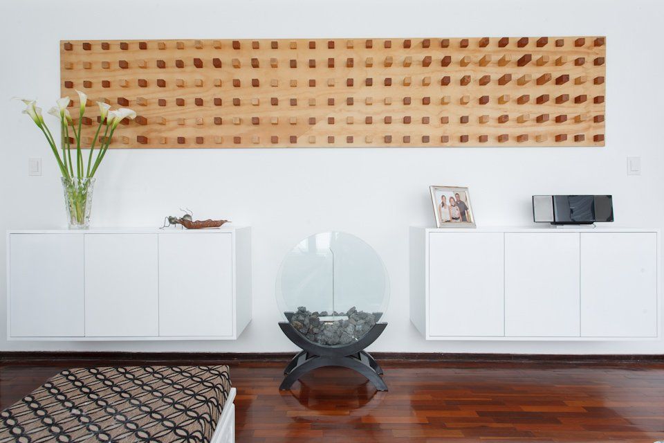 Una sala de estar con armarios blancos y una mesa de cristal.