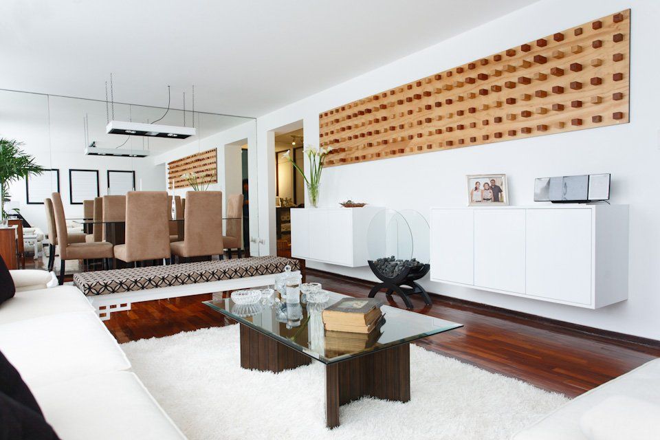 Una sala de estar con una mesa de centro de cristal y un comedor al fondo.