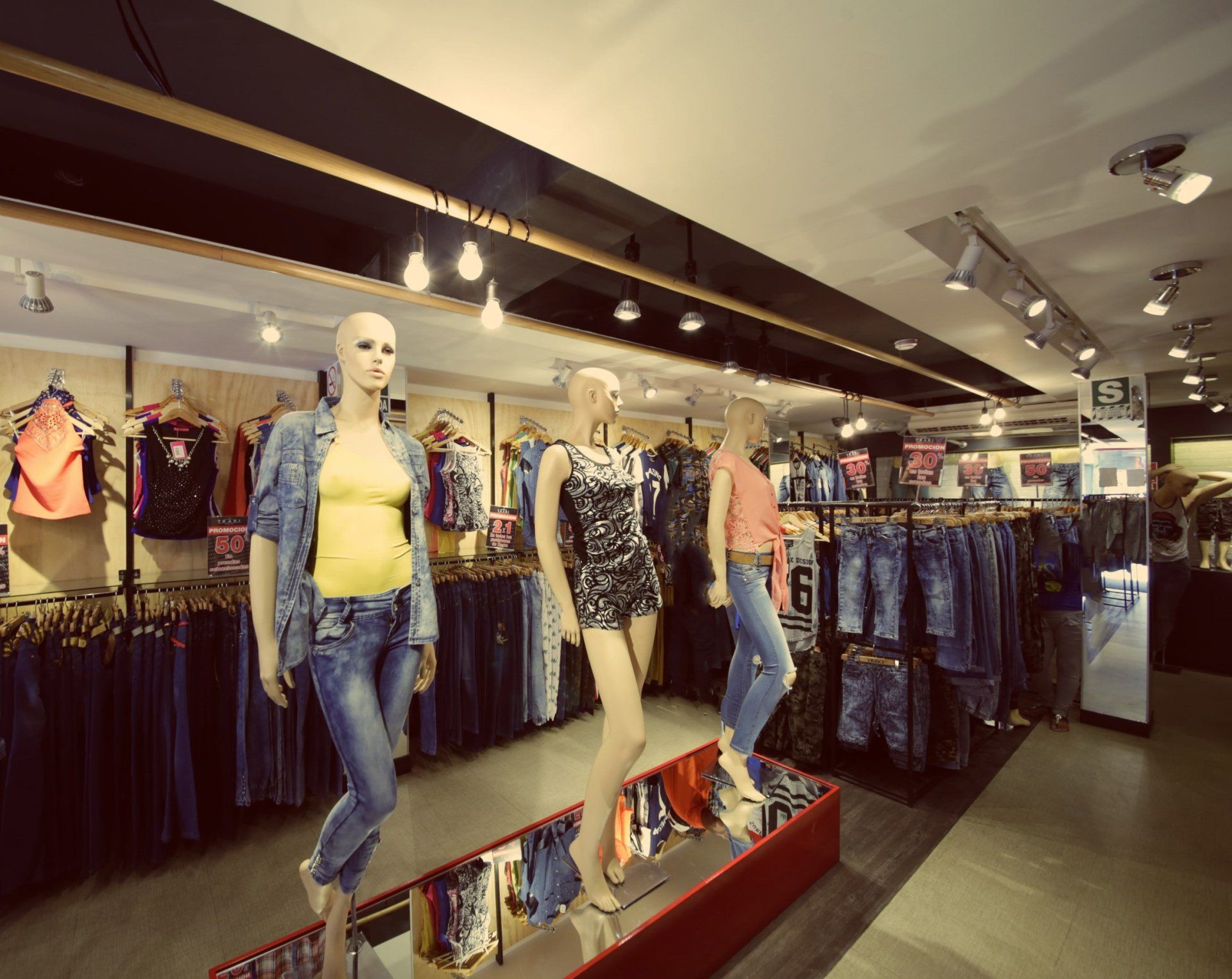 Tres maniquíes están de pie en una tienda de ropa.