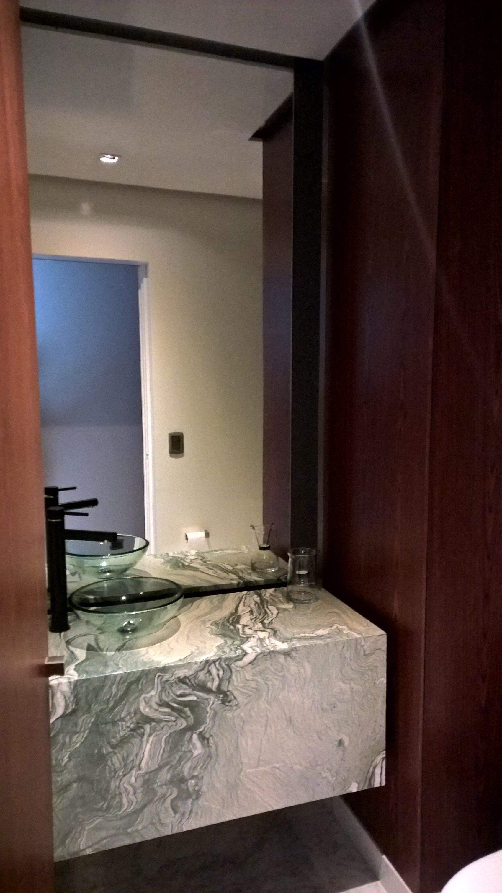 Un baño con lavabo, espejo e inodoro.