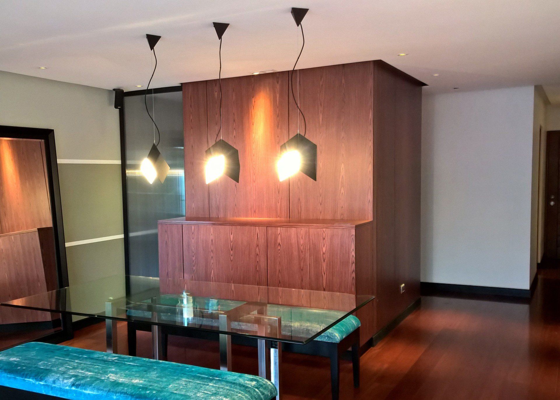 Una sala de estar con una mesa de cristal y un espejo.
