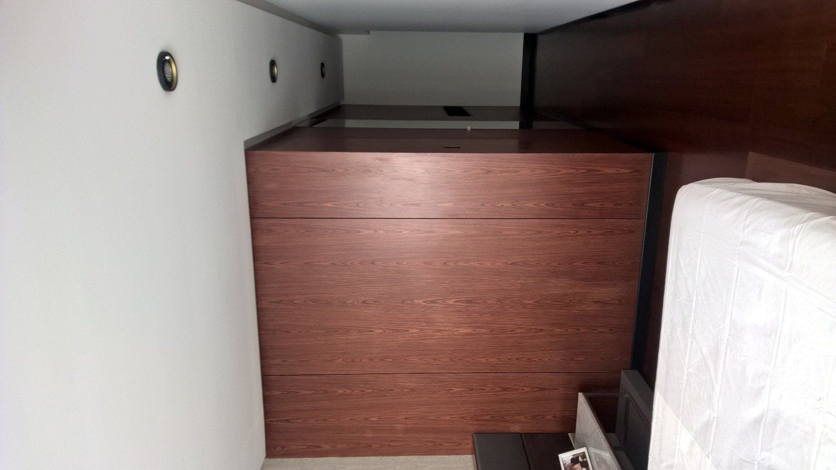 Un dormitorio con una cómoda de madera y una cama.