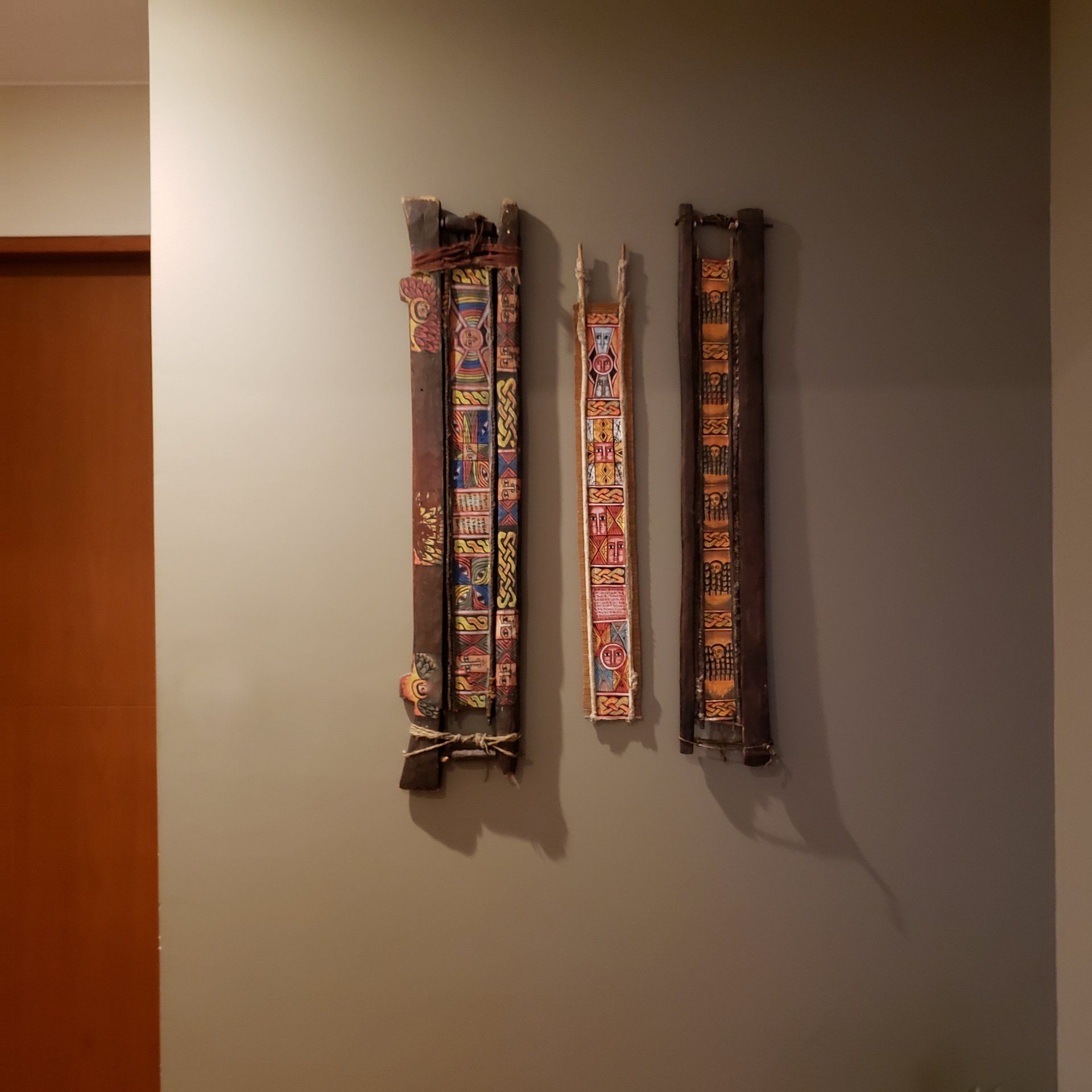 Hay tres cuadros colgados en una pared de un pasillo.