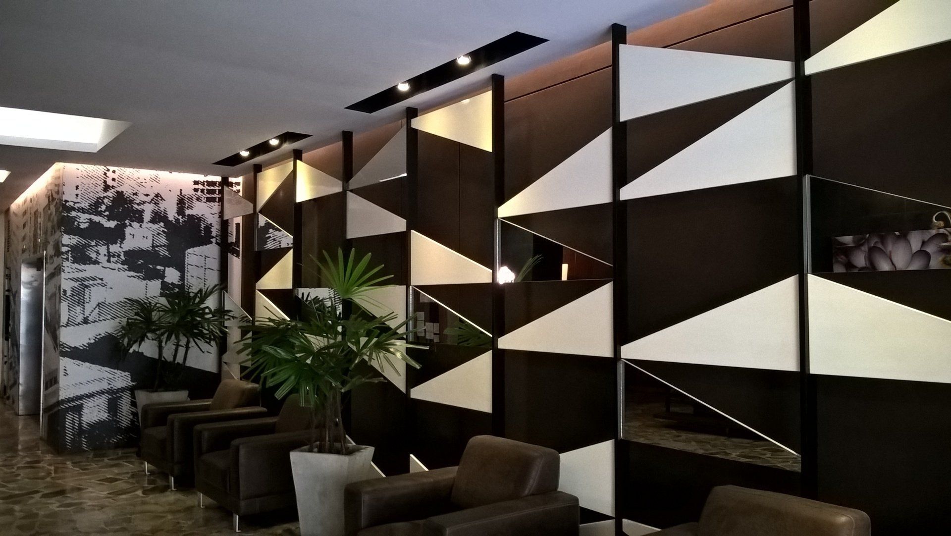Una habitación con sillas y una pared con triángulos.