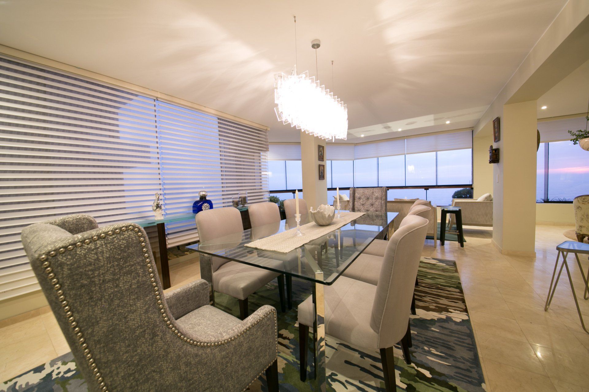 Un comedor con una mesa de cristal y sillas.