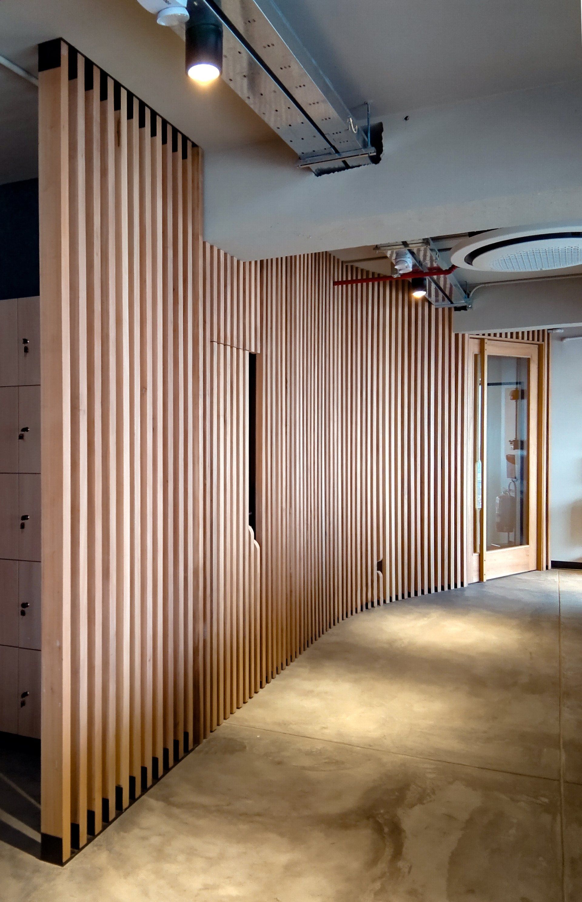 Un pasillo con una pared de madera y una puerta.