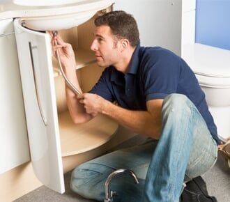 Plumber working on sink Plumber working on sink