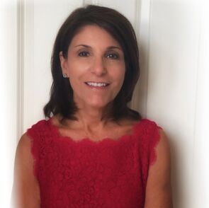 A woman in a red dress is smiling for the camera.