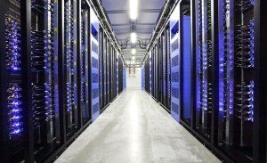 a long corridor in a data centre with blue lights illuminating the black casing either side