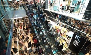 An overhead view of a busy Primark shop floor with people on escalators and queuing