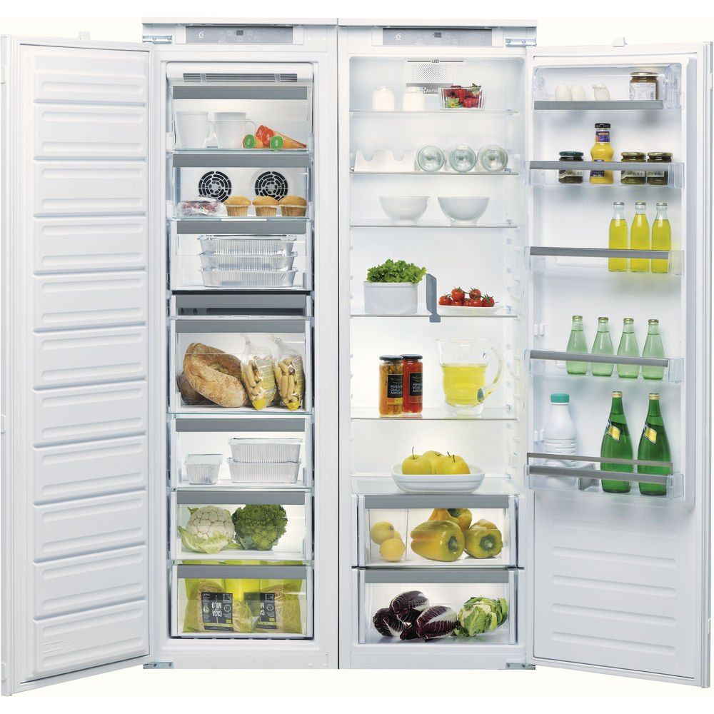 Un mobiletto affiancato bianco, composto da frigorifero e congelatore, con ripiani e cassetti in vetro, pieno di alimenti e bevande di vario genere.