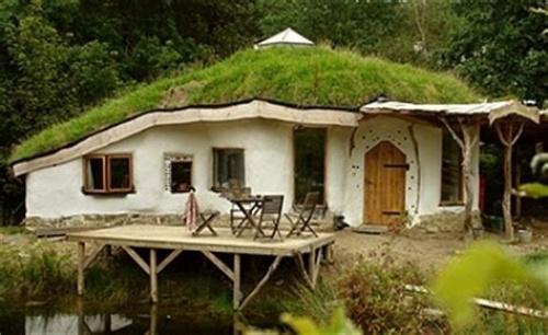 Organische woning.  een houten veranda in een weelderig bosrijke omgeving.