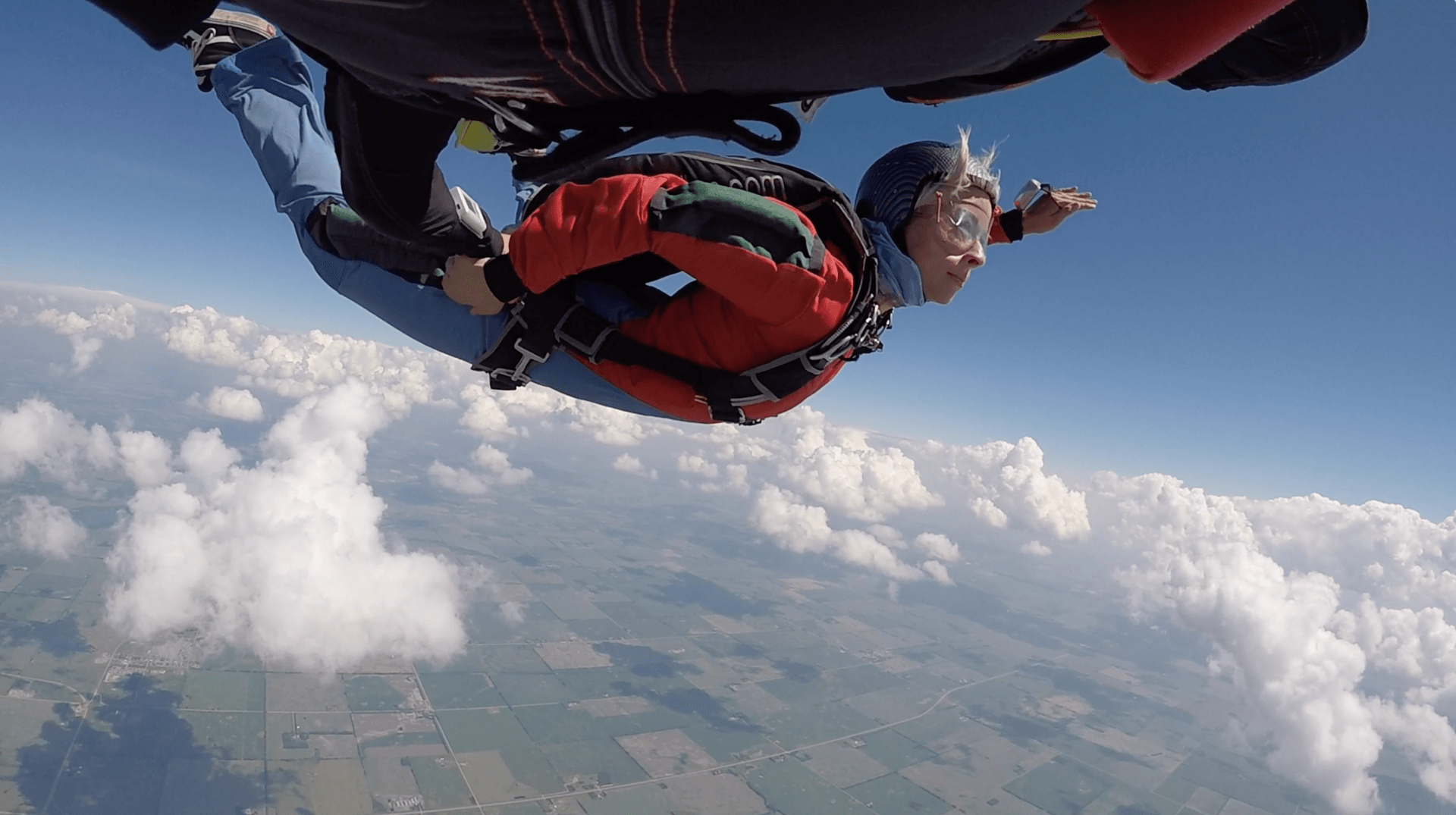 A person is flying through the air with a parachute.