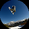A snowboarder is doing a trick in the air.