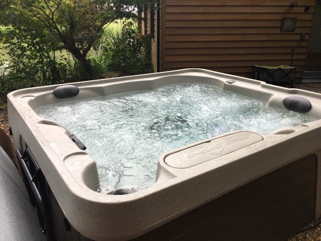 A hot tub bubbles away awaiting the next guests at the riverside Lodg ein the New Forest