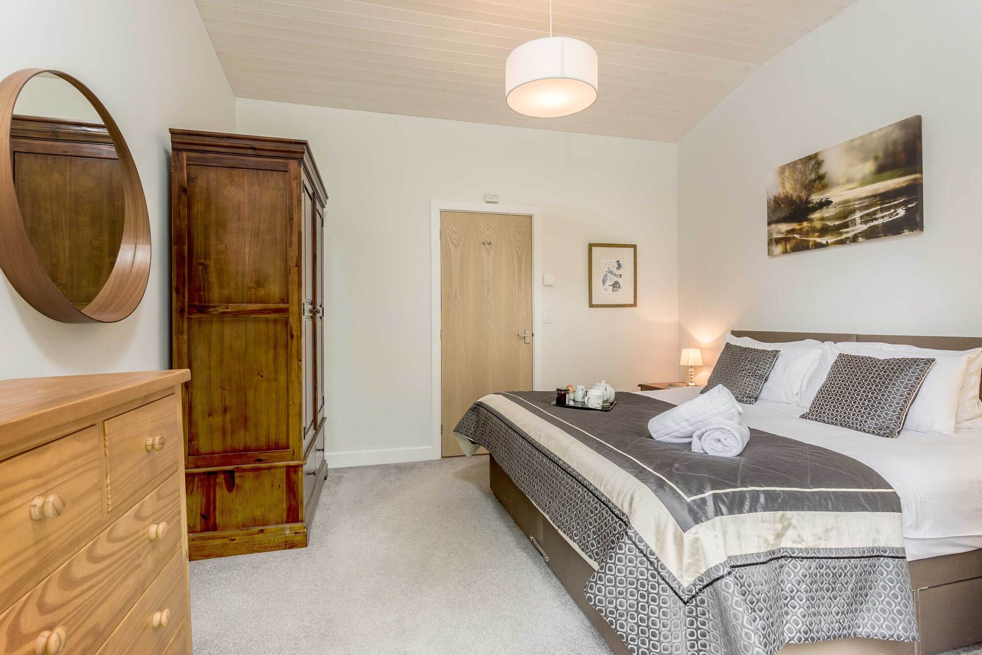 large bed with luxury bedspread and towels ready for guests