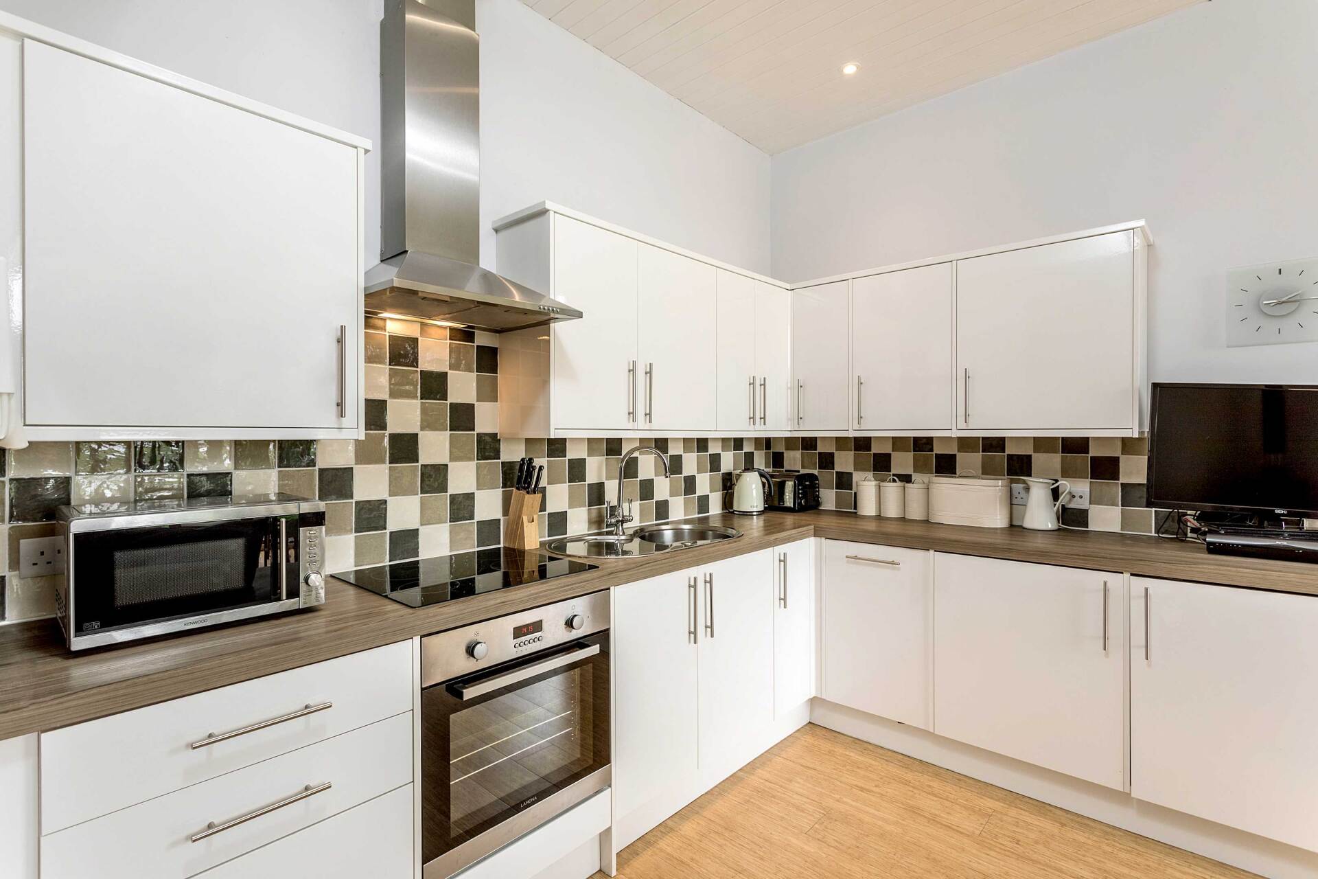 Contemporary fully  equipped kitchen with white units