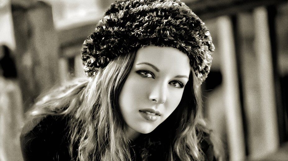 A black and white photo of a woman wearing a fur hat
