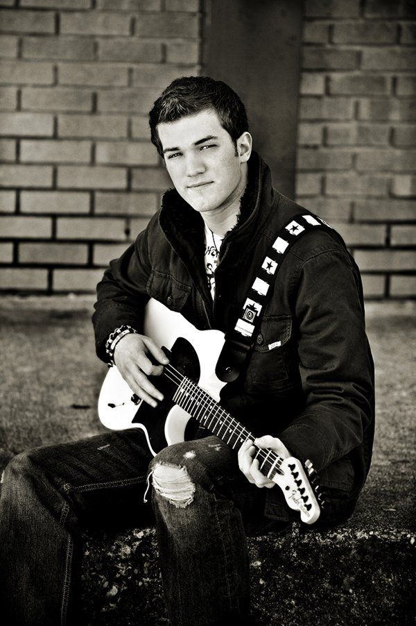 A black and white photo of a young man holding a guitar