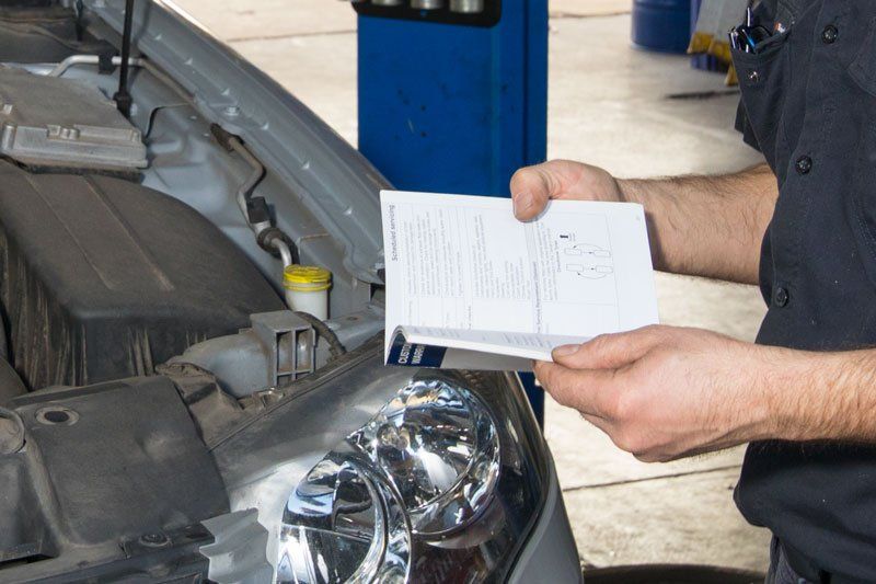 Checking Log Book for Repairs — Automotive Servicing in New Lambton, NSW