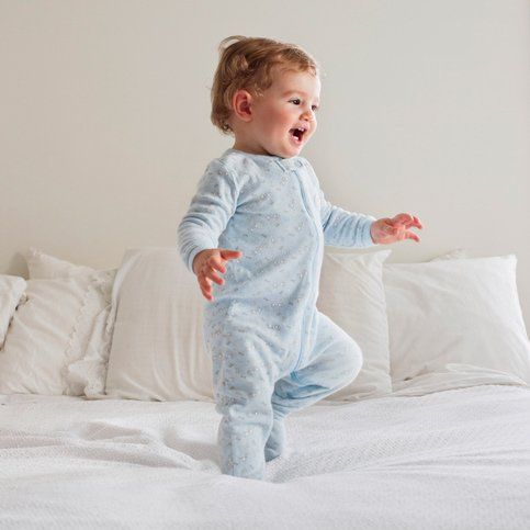 toddler jumping on bed