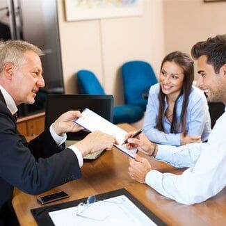 Real Estate — Couple Reviewing a Real Estate Contract in Lapeer, MI Real Estate — Couple Reviewing a Real Estate Contract in Lapeer, MI