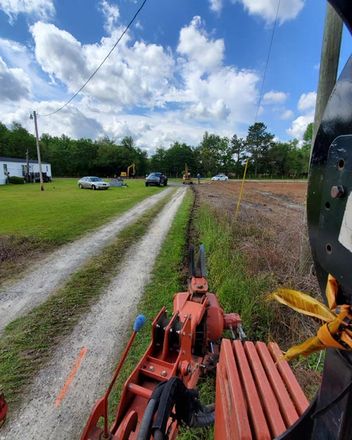 orange tractor digging trench