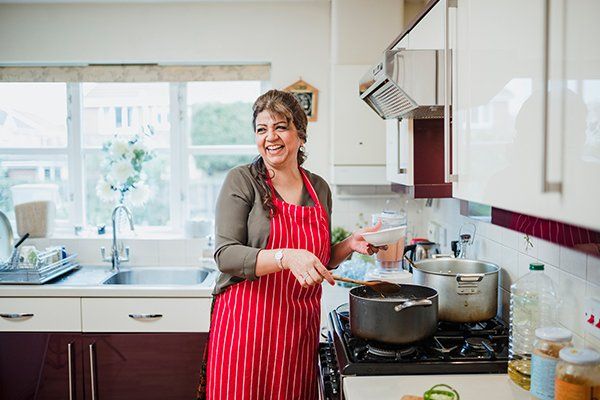Woman Enjoying Cooking at Home — Cape Cod, MA — Cape Appliance Repairs Woman Enjoying Cooking at Home — Cape Cod, MA — Cape Appliance Repairs