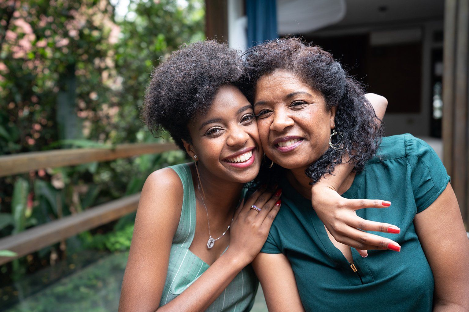 A mother and daughter are posing for a picture together.