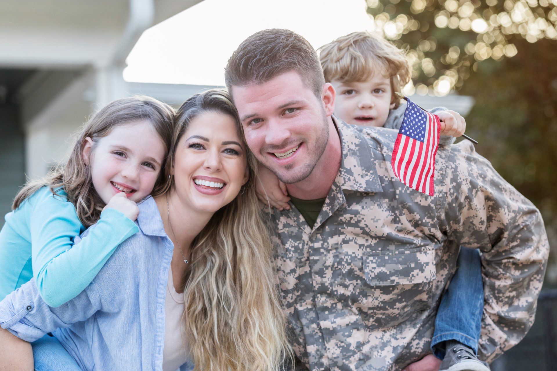 A man in a military uniform is posing for a picture with his family.