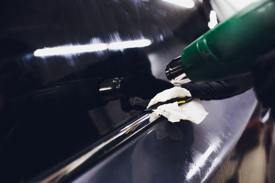 Window Tint Denton — Applying Tinting Foil On Car Window In Garage in Lewisville, TX Window Tint Denton — Applying Tinting Foil On Car Window In Garage in Lewisville, TX