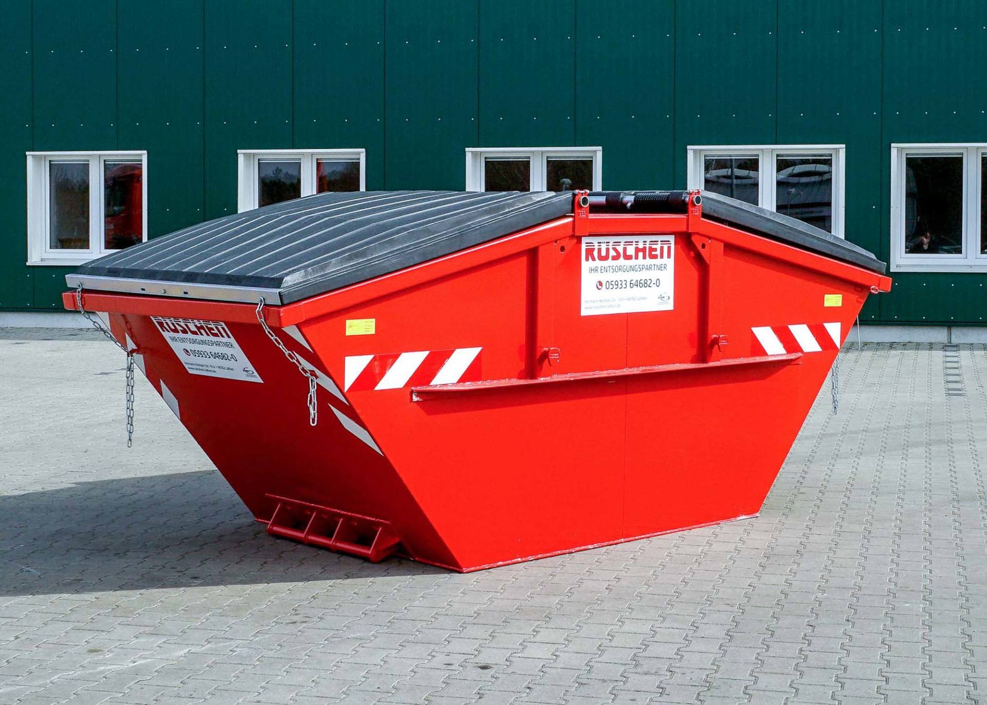 Rüschen Absetzcontainer Ein roter Absetzcontainer mit dem Wort „Rüschen“ darauf