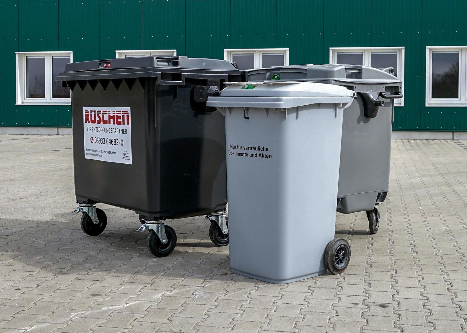 Rüschen Altaktenbehälter Drei Altaktenbehälter stehen vor einem grünen Gebäude aufgereiht