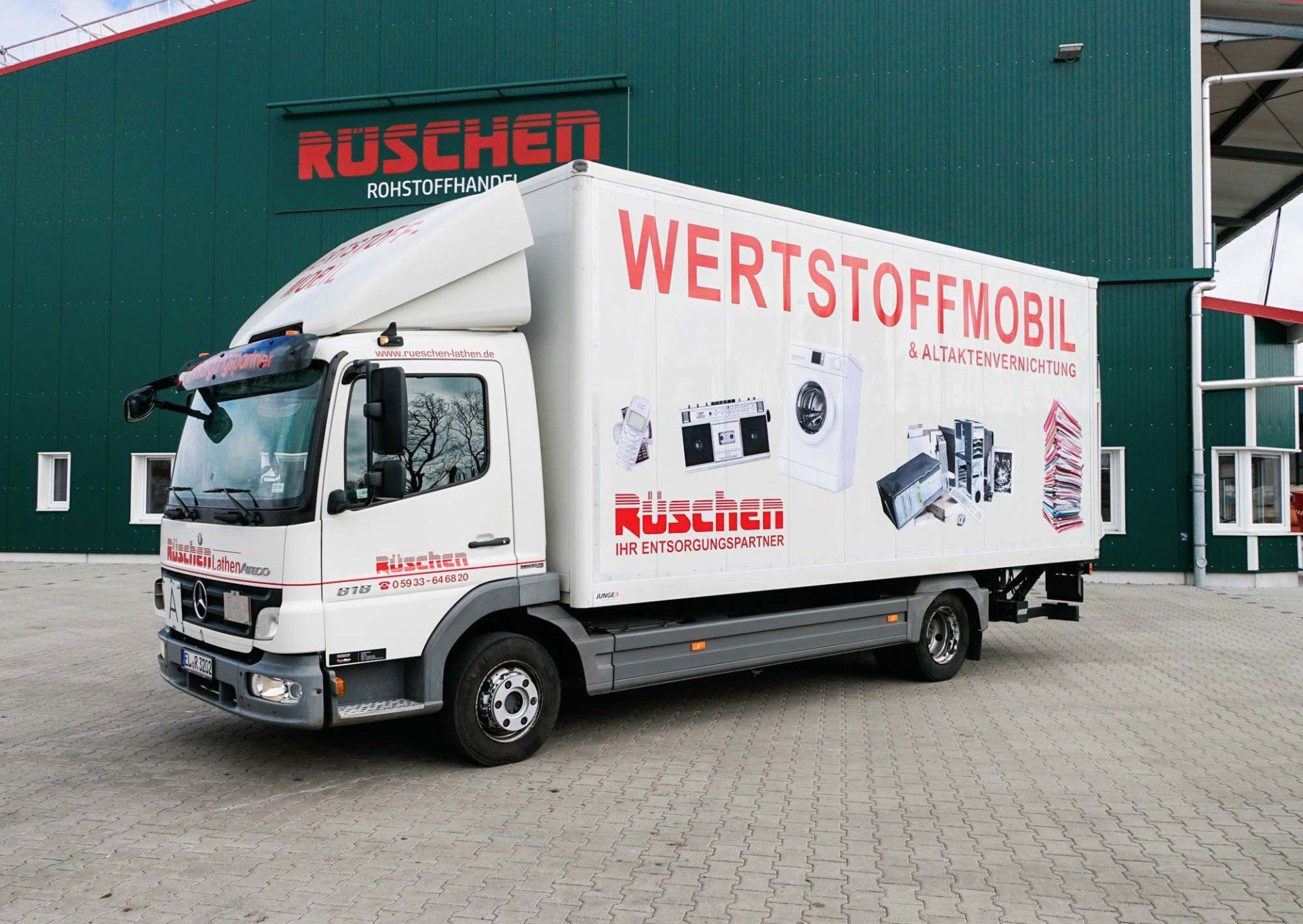 Rüschen Kofferfahrzeuge Ein weißer Kofferfahrzeug mit dem Wort Wertstoffmobil an der Seite