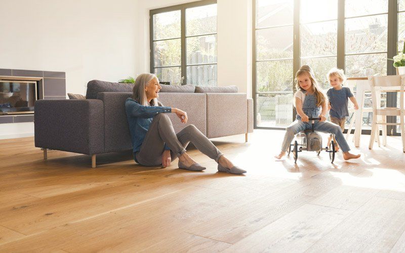woman watching children play on wood floor
