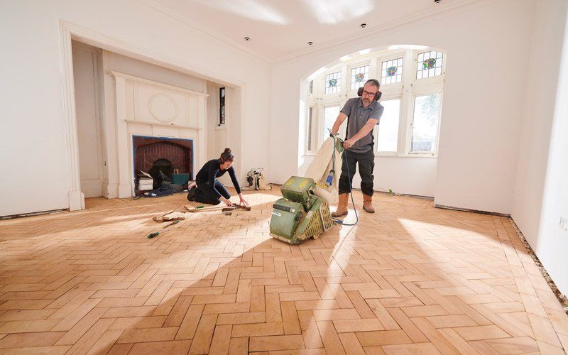 people sanding wood floor