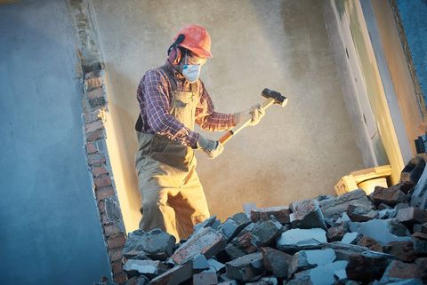 worker demolishing the concrete wall