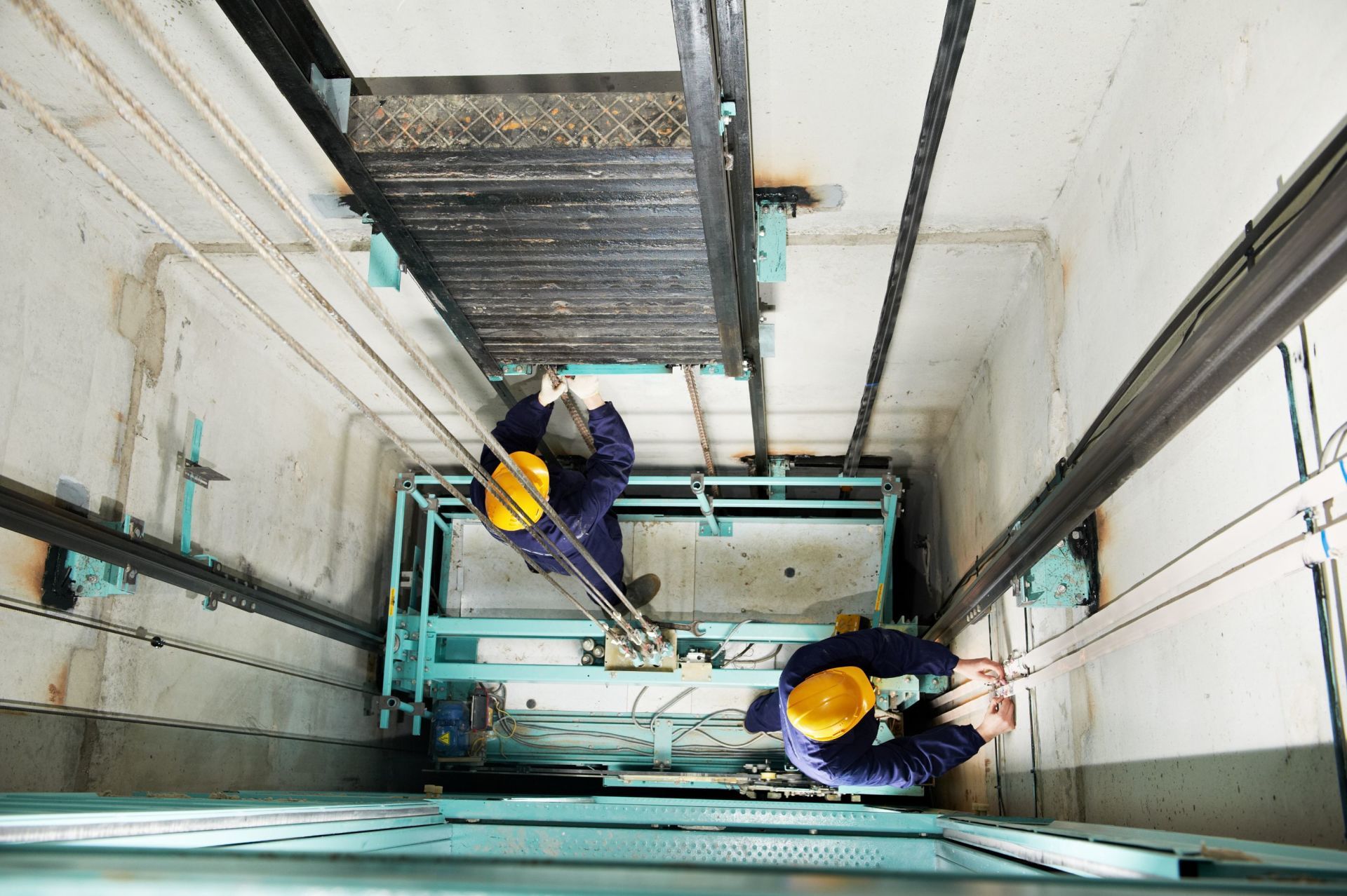 Due uomini stanno lavorando su un ascensore in un edificio.