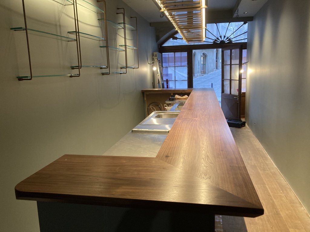 Un long comptoir en bois dans une pièce avec une fenêtre