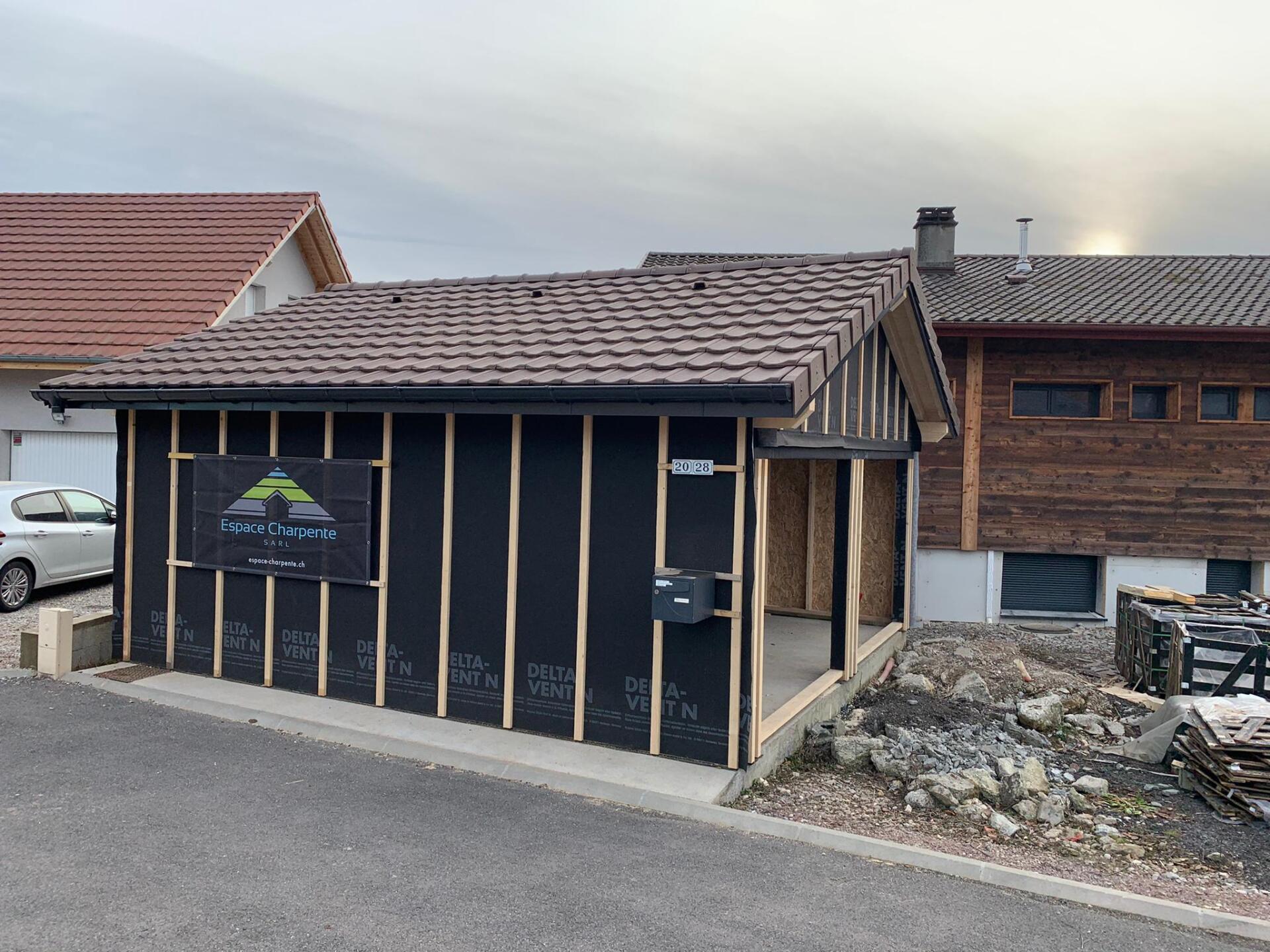 Une maison en construction avec une voiture garée devant.