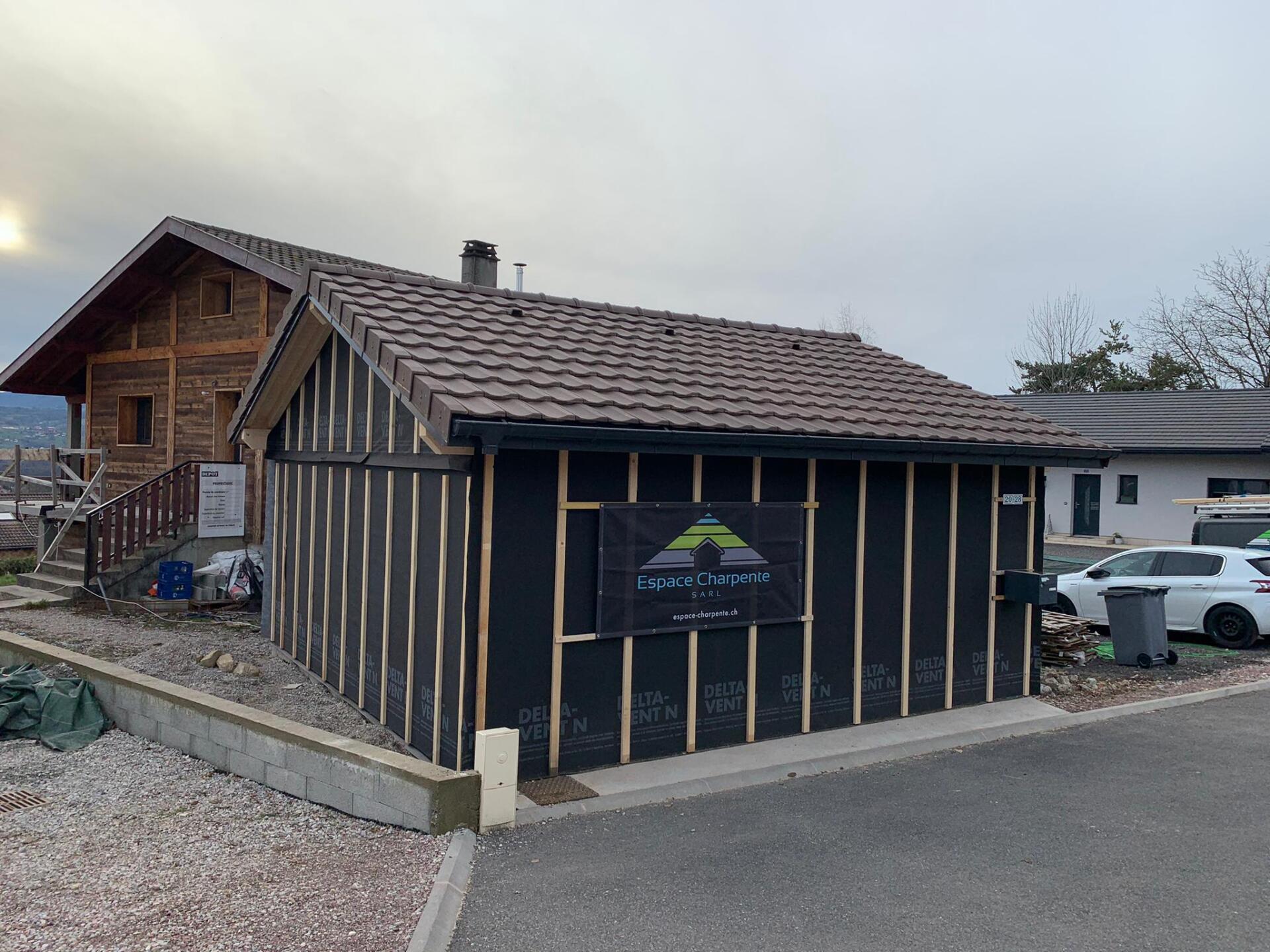 Une petite maison est en construction au bord de la route.