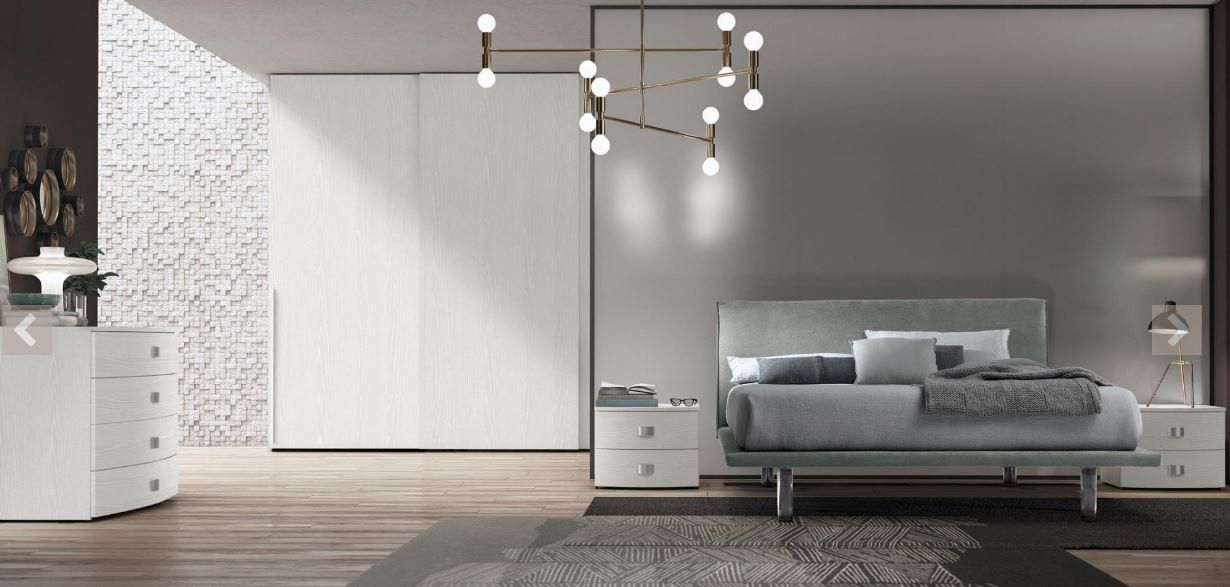 Camera da letto moderna e minimalista con letto grigio, armadio bianco, pavimento in legno e lampade a sospensione.