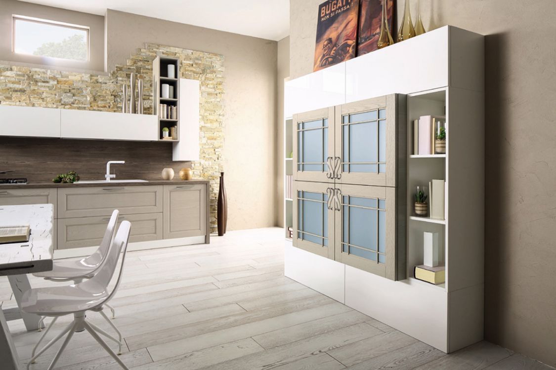Cucina moderna con mobili bianchi, isola grigia e frigorifero blu a doppia porta in una stanza luminosa