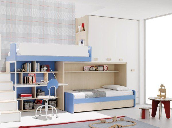 Moderno letto a soppalco per bambini, bianco e blu, con scrivania, mensole e letto estraibile, ideale per una camera da letto luminosa.